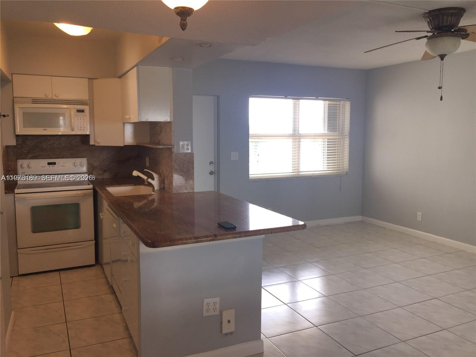901 South Surf Road, Unit 402 Hollywood, FL 33019 - Photo 21 of 25 a kitchen with a sink a stove and cabinets