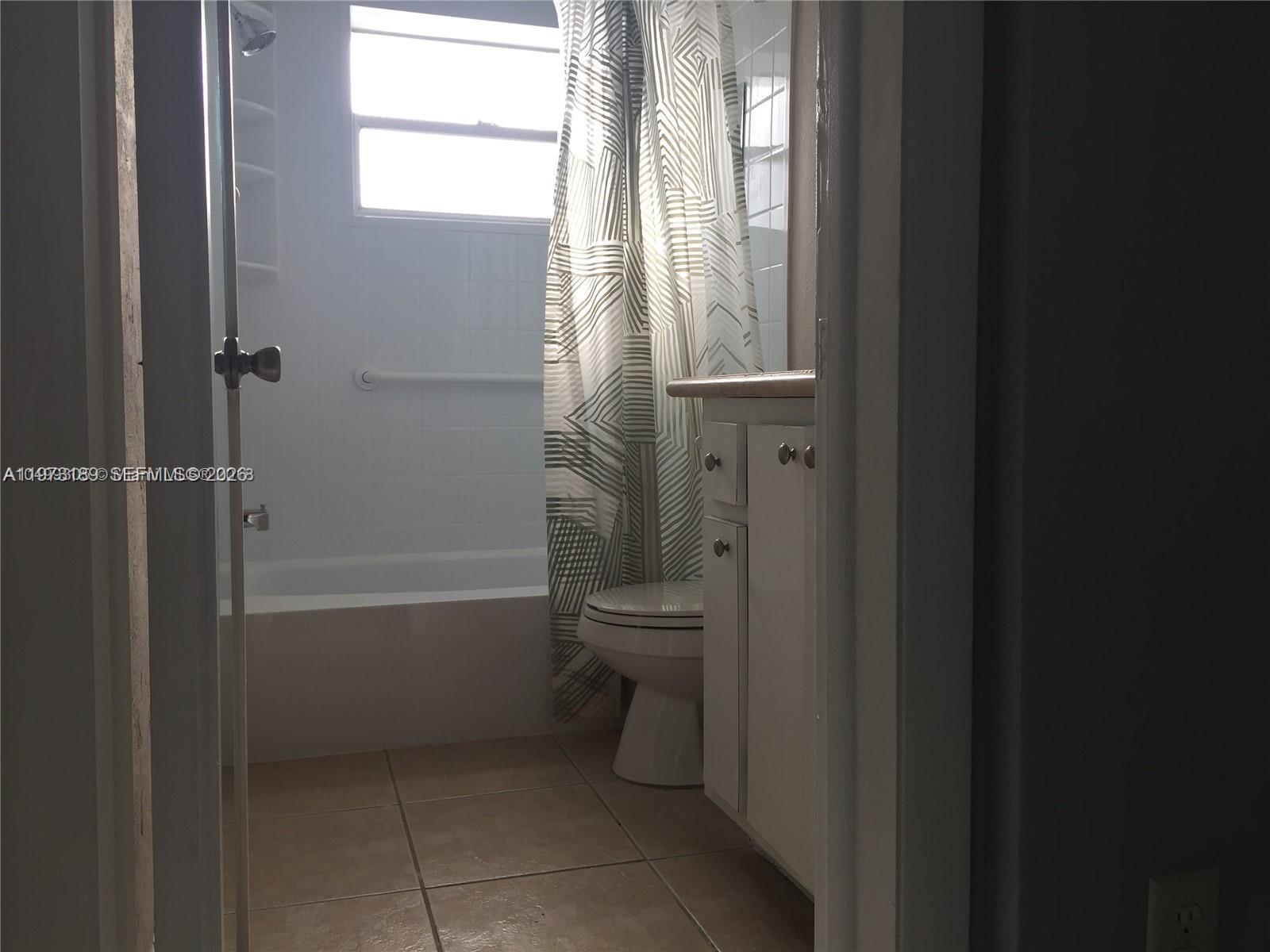 901 South Surf Road, Unit 402 Hollywood, FL 33019 - Photo 25 of 25 a bathroom with a granite countertop toilet a sink and a bathtub