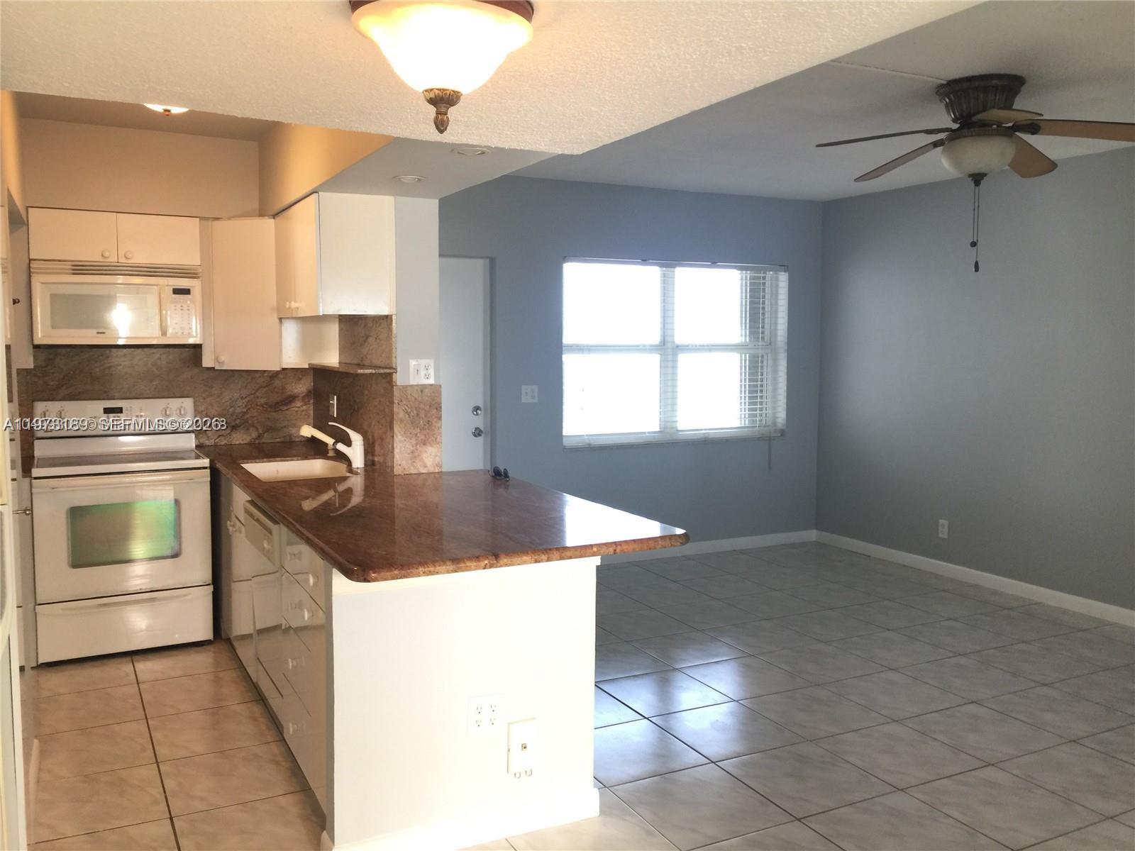 901 South Surf Road, Unit 402 Hollywood, FL 33019 - Photo 6 of 25 a kitchen with a sink stove and cabinets