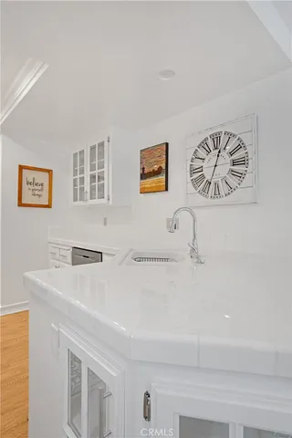 a view of hallway that has two painting on the wall and a potted plant