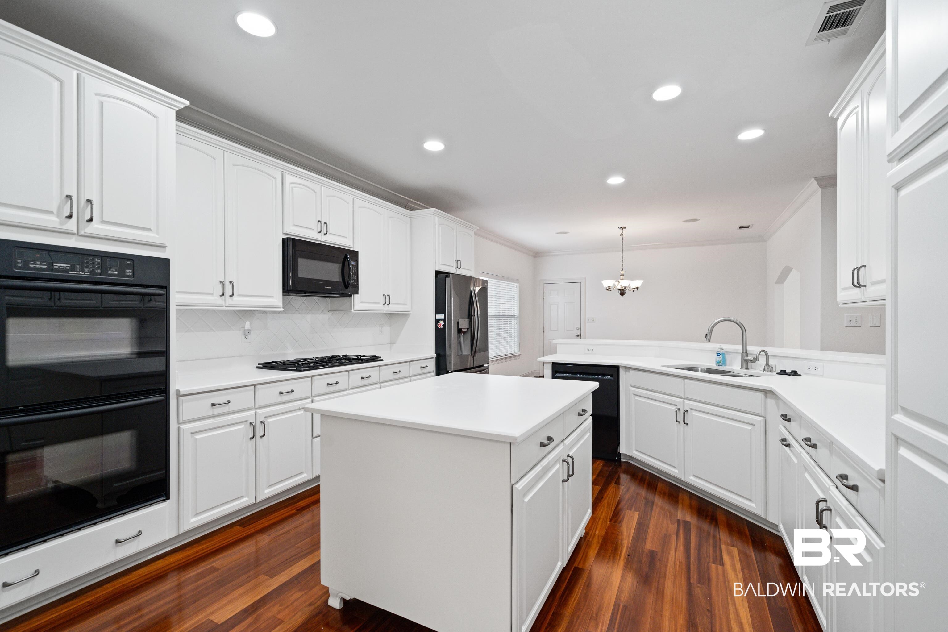 404 Savannah Lane Foley, AL 36535 - Photo 16 of 29 Kitchen with light countertops, a sink, a peninsula, and black appliances