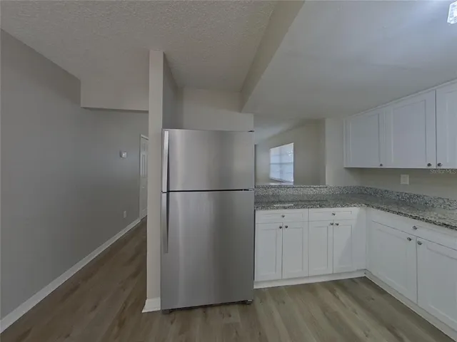 a kitchen with a refrigerator sink and cabinets