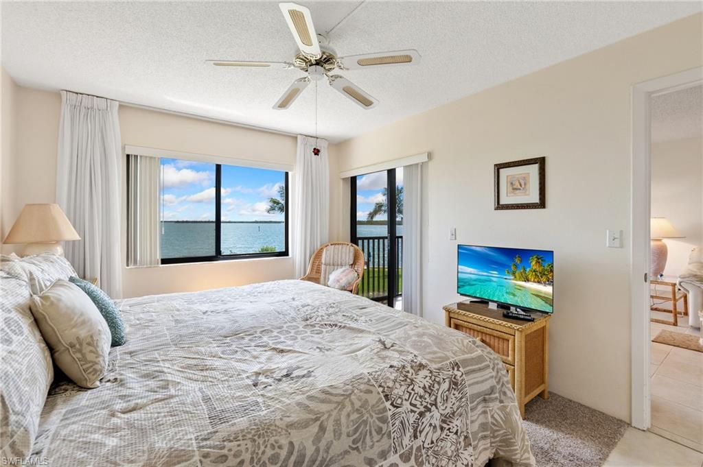 400 Lenell Road, Unit 110 Fort Myers Beach, FL 33931 - Photo 16 of 37 a bedroom with a bed and a flat screen tv