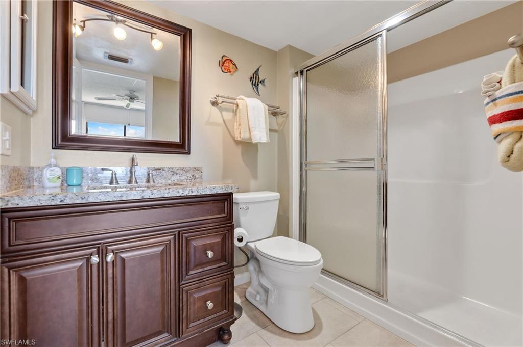400 Lenell Road, Unit 110 Fort Myers Beach, FL 33931 - Photo 20 of 37 a bathroom with a granite countertop sink a toilet and a mirror