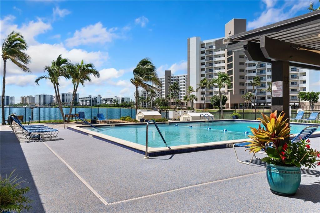 400 Lenell Road, Unit 110 Fort Myers Beach, FL 33931 - Photo 21 of 37 a view of a swimming pool with a lounge chair and palm trees