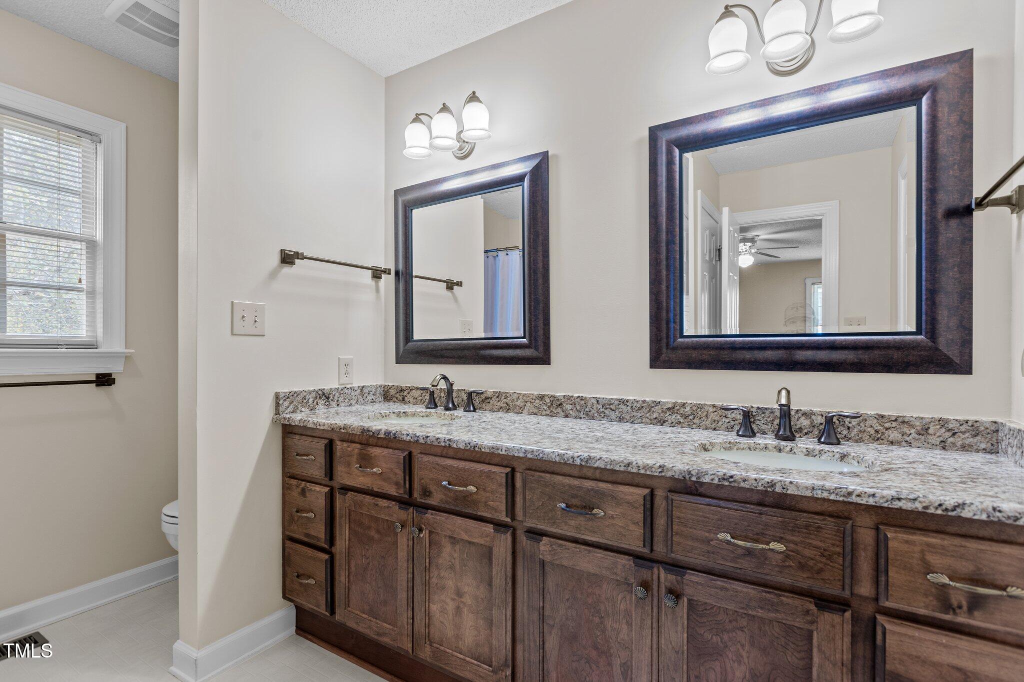 5940 Hampton Ridge Road Raleigh, NC 27603 - Photo 16 of 42 a bathroom with 2 sink and a mirror