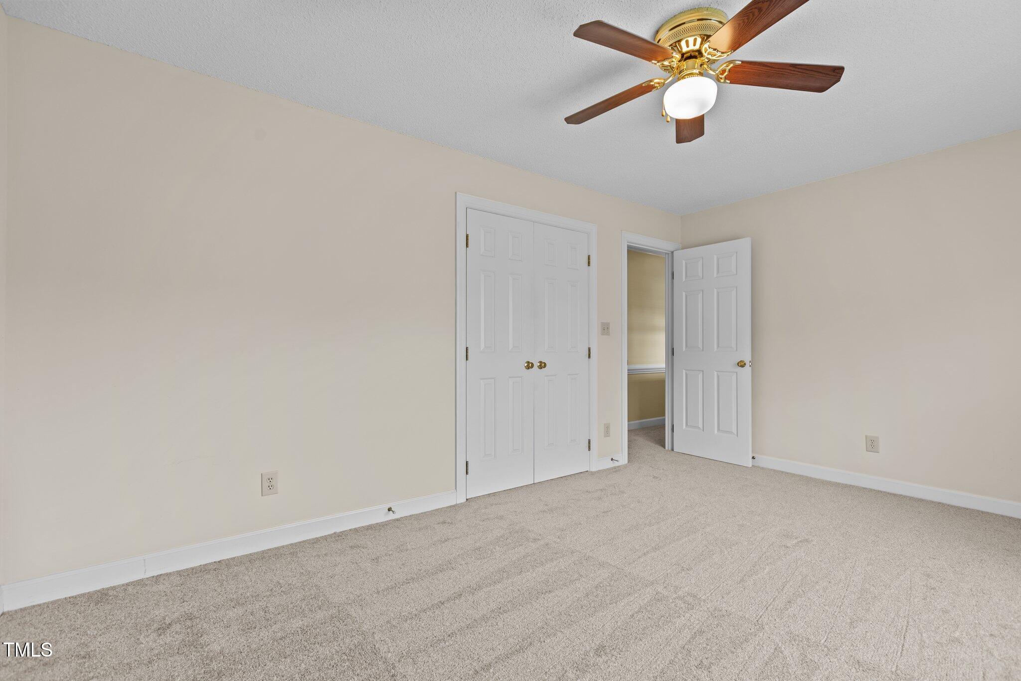 5940 Hampton Ridge Road Raleigh, NC 27603 - Photo 21 of 42 an empty room with closet and a chandelier fan