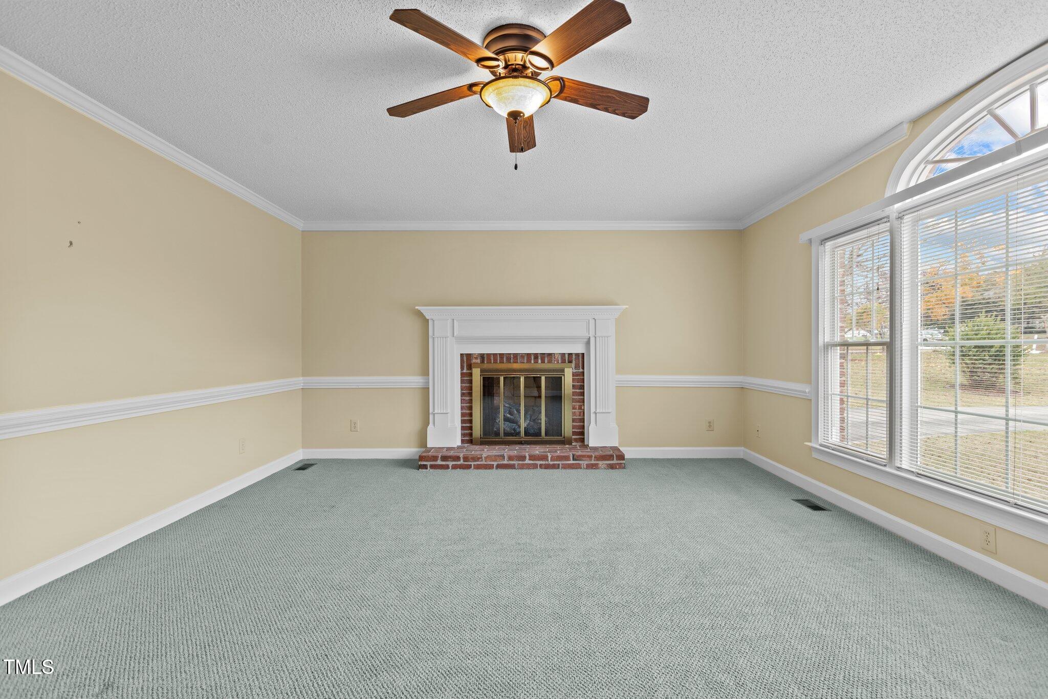 5940 Hampton Ridge Road Raleigh, NC 27603 - Photo 7 of 42 an empty room with chandelier fan and windows