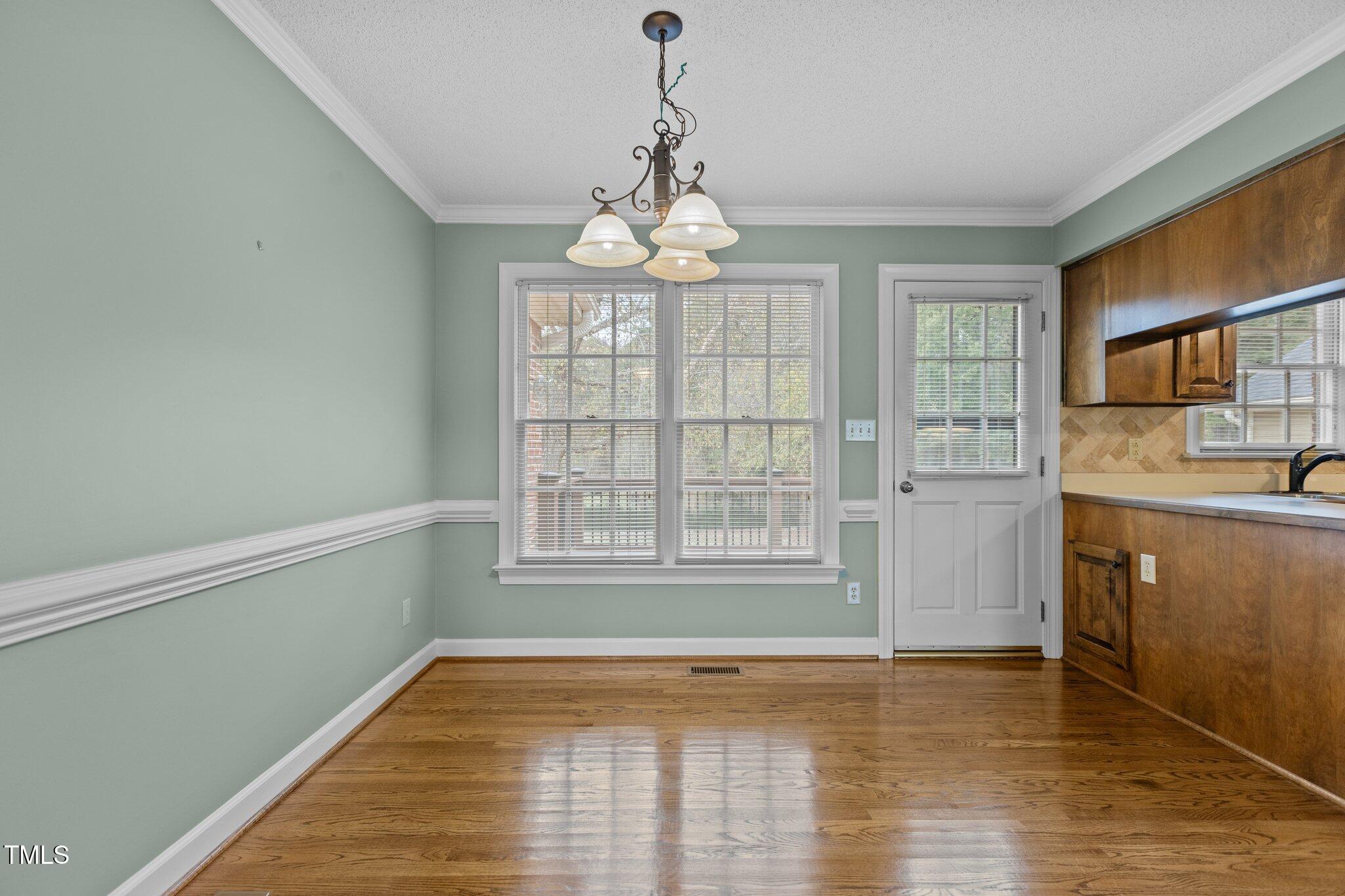 5940 Hampton Ridge Road Raleigh, NC 27603 - Photo 10 of 42 a view of an empty room with a window and wooden floor