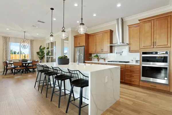 a kitchen with a table chairs stove and cabinets