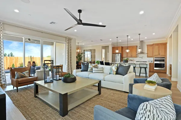 a living room with furniture kitchen view and a large window