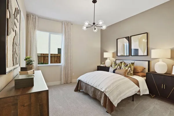 a bedroom with a large bed and a chandelier