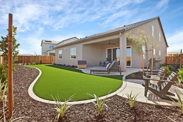 a view of a house with backyard sitting area and furniture