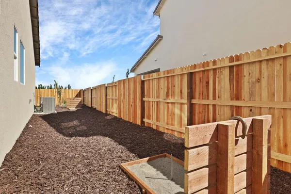a view of a backyard with wooden fence