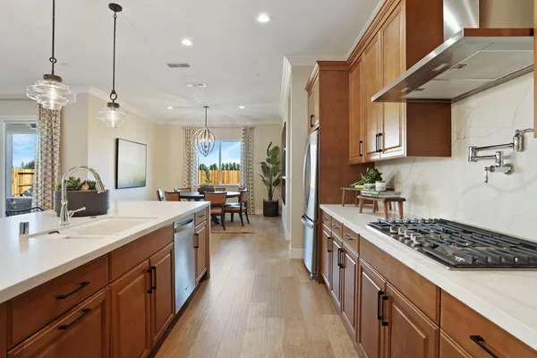 a kitchen with stainless steel appliances a stove a sink dishwasher and a wooden cabinets