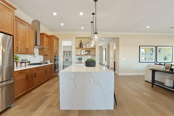 a large kitchen with kitchen island a large counter space and stainless steel appliances