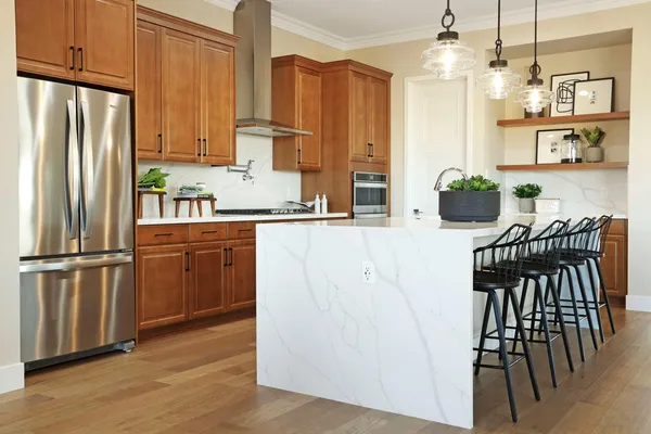 a kitchen with stainless steel appliances granite countertop a refrigerator a stove a sink dishwasher and white cabinets with wooden floor