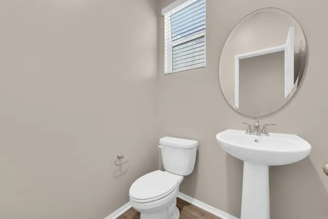 a bathroom with a toilet sink and mirror
