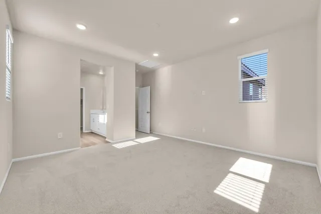 an empty room with windows and ceiling fan