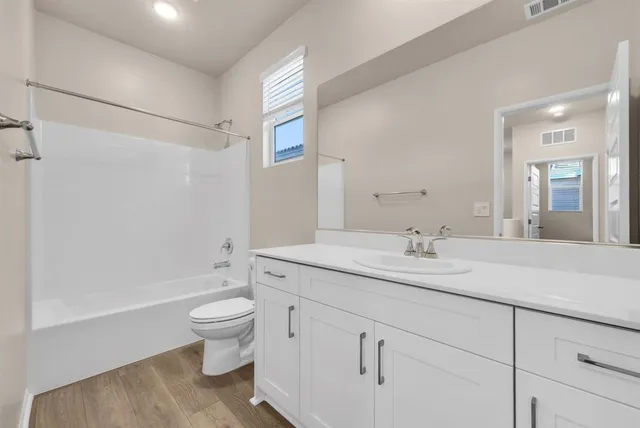 a spacious bathroom with a granite countertop sink toilet and shower