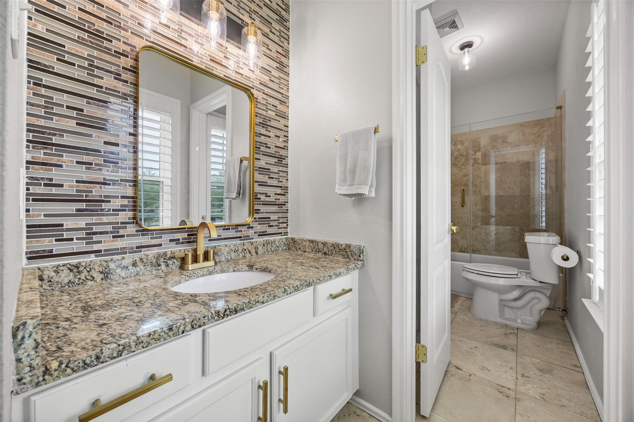 8610 Axis Drive Austin, TX 78749 - Photo 22 of 29 a bathroom with a granite countertop sink a toilet and a mirror