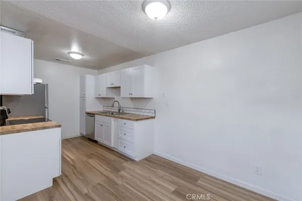 a kitchen with granite countertop white cabinets and white appliances