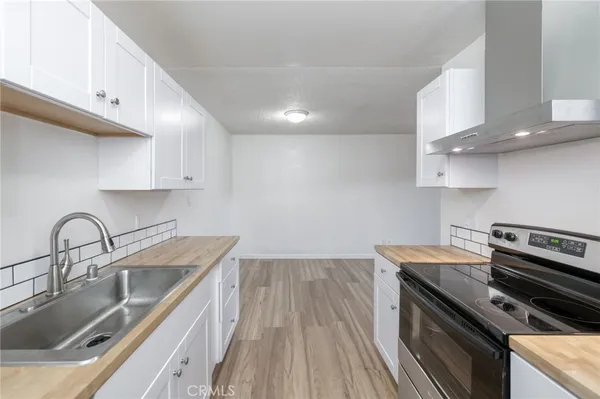 a kitchen with a sink stove top oven and cabinets