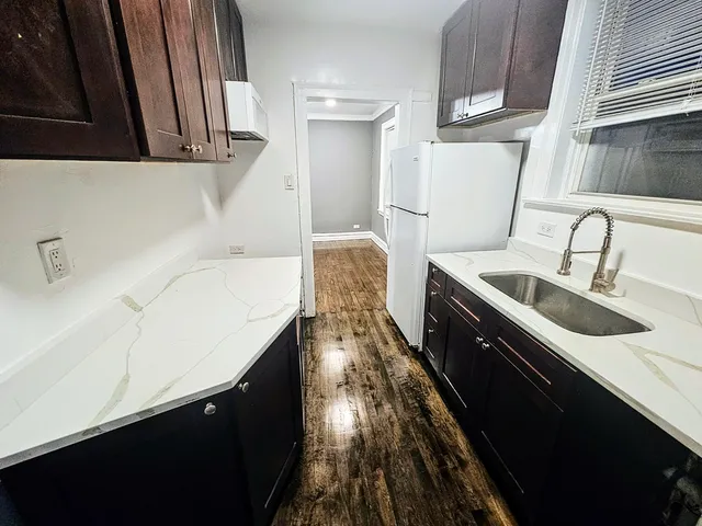 a kitchen with a sink and wooden floor
