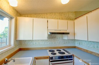 1214 36th Street Anacortes, WA 98221 - Photo 6 of 23 a kitchen with a sink a stove and a window