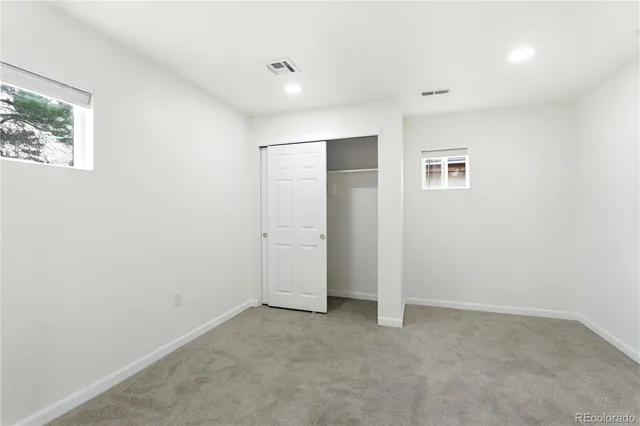 an empty room with windows and closet