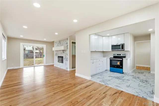 a kitchen with granite countertop a stove top oven and refrigerator