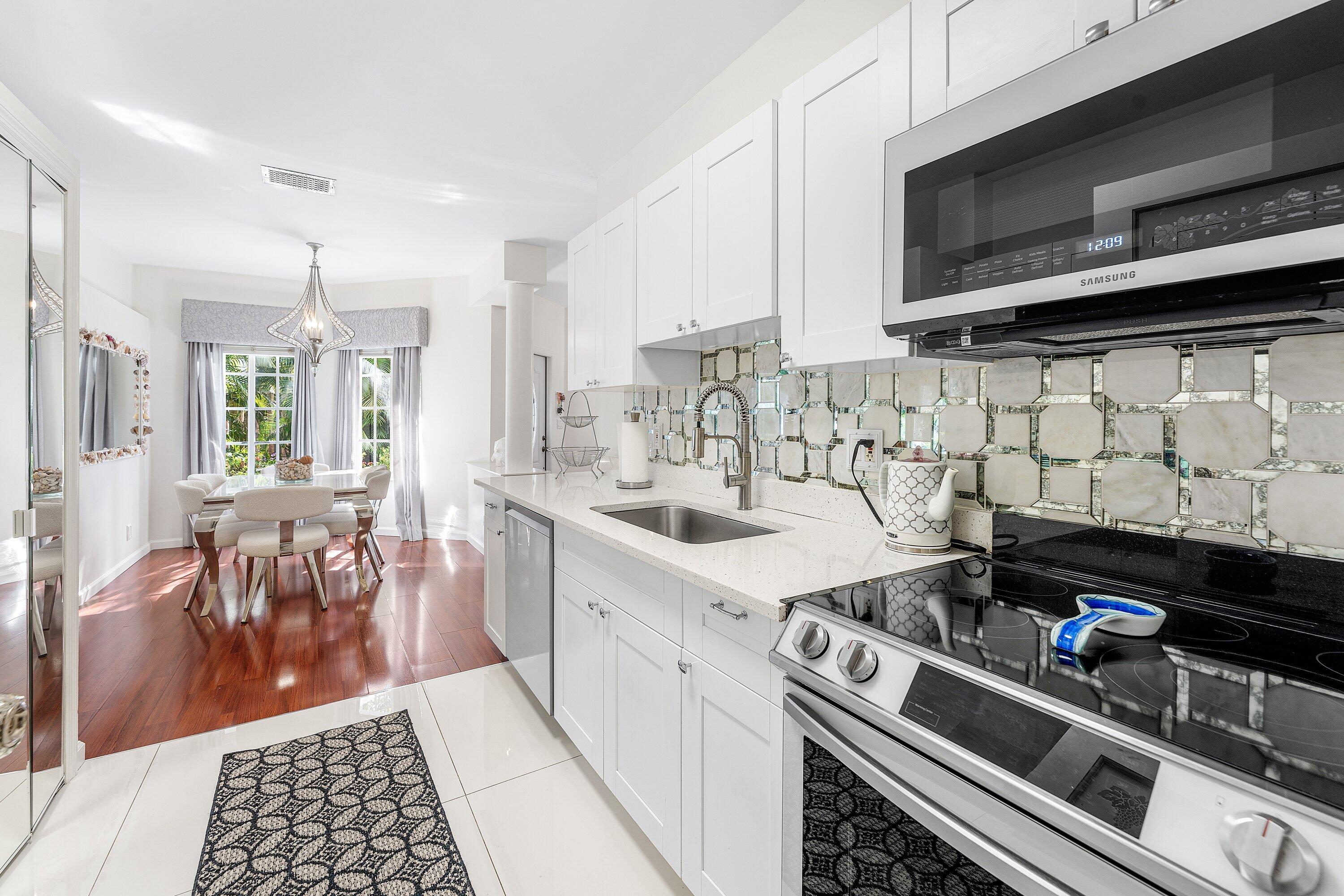 20 South Lakeshore Drive, Unit C Hypoluxo, FL 33462 - Photo 12 of 55 a kitchen with a sink stove and cabinets