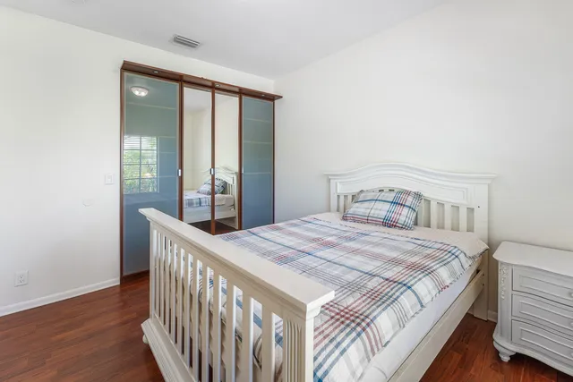 a bedroom with a bed and wooden floor