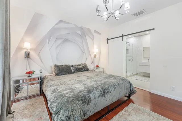 a bedroom with a bed and a chandelier