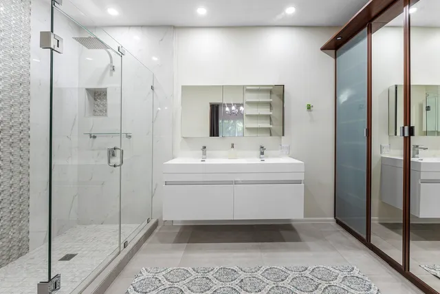 a bathroom with a sink mirror and shower