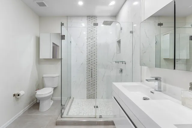 a bathroom with a sink a toilet and shower