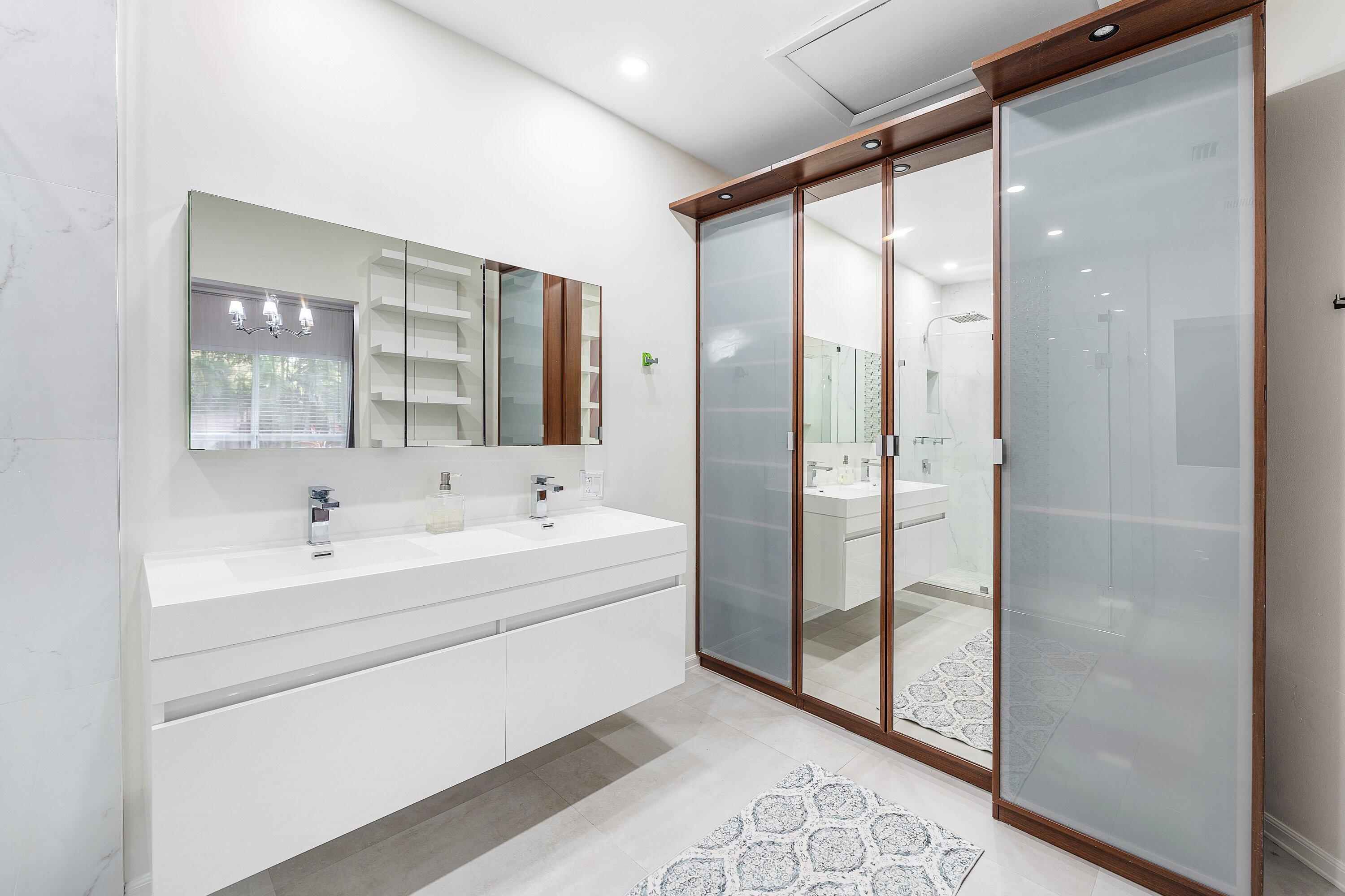 20 South Lakeshore Drive, Unit C Hypoluxo, FL 33462 - Photo 25 of 55 a bathroom with a bathtub and a double vanity sink