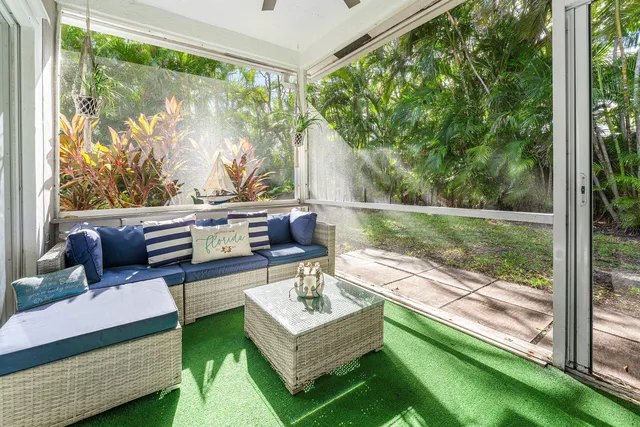 a living room with patio furniture and a garden