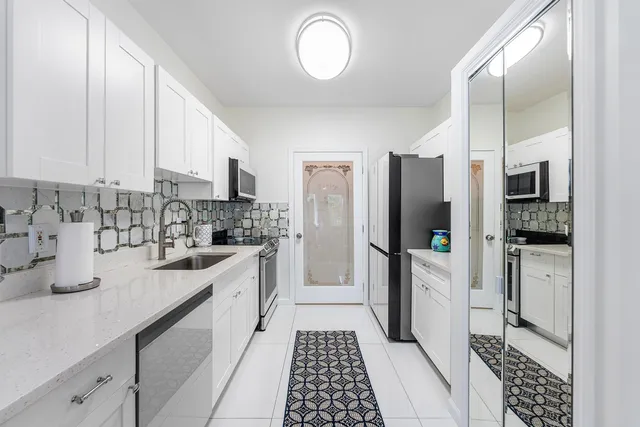 a kitchen with stainless steel appliances a refrigerator sink and cabinets