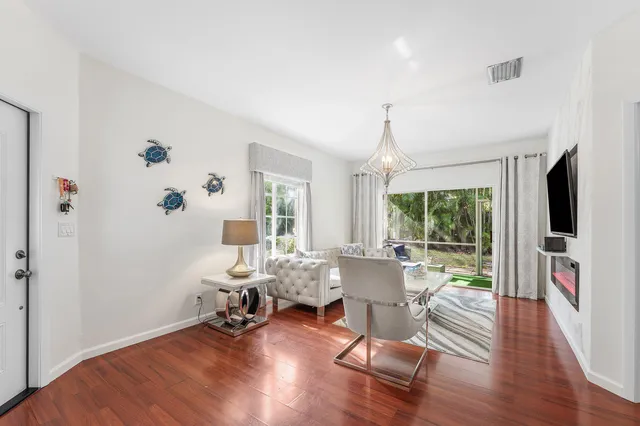 a living room with furniture floor to ceiling window and wooden floor