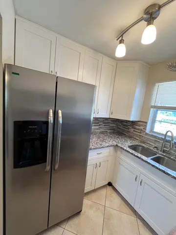 a kitchen with granite countertop a refrigerator and a sink
