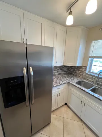 a kitchen with granite countertop a sink stove and refrigerator