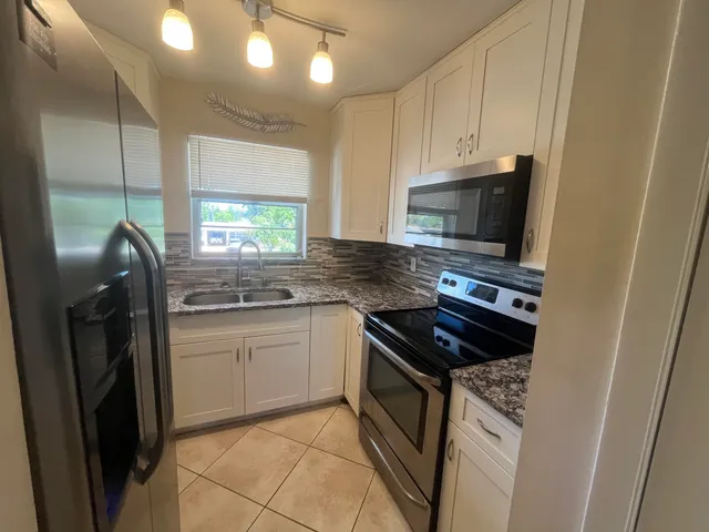 a kitchen with stainless steel appliances a sink stove and refrigerator