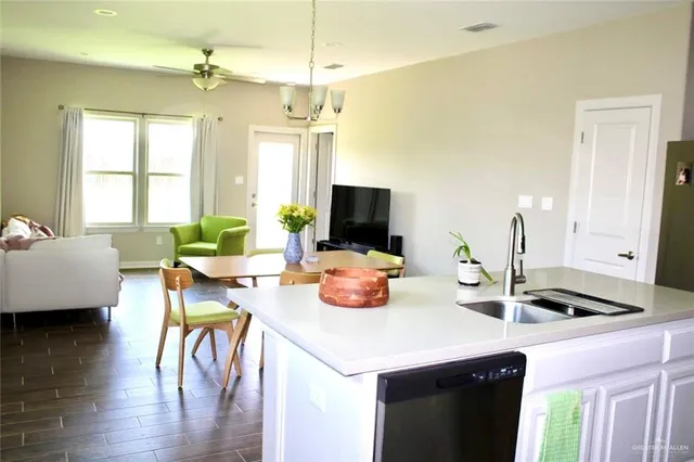 a kitchen with sink and view of living room