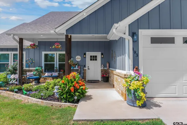 a front view of a house with lots of potted plants
