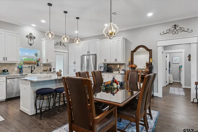 a view of a dining room and livingroom with furniture wooden floor a chandelier