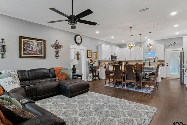 a living room with furniture a ceiling fan and a rug