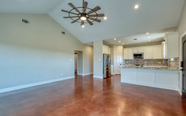 a view of a kitchen with a stove cabinets wooden floor and a kitchen view