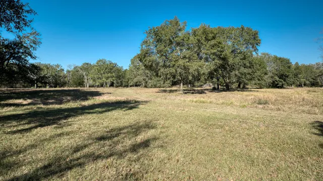 a view of dirt yard with wooden fence