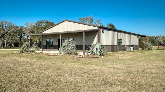 a view of a house with backyard and trees